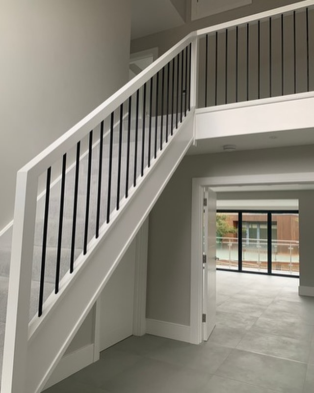 modern staircase renovation with metal spindles and painted oak up and over handrail